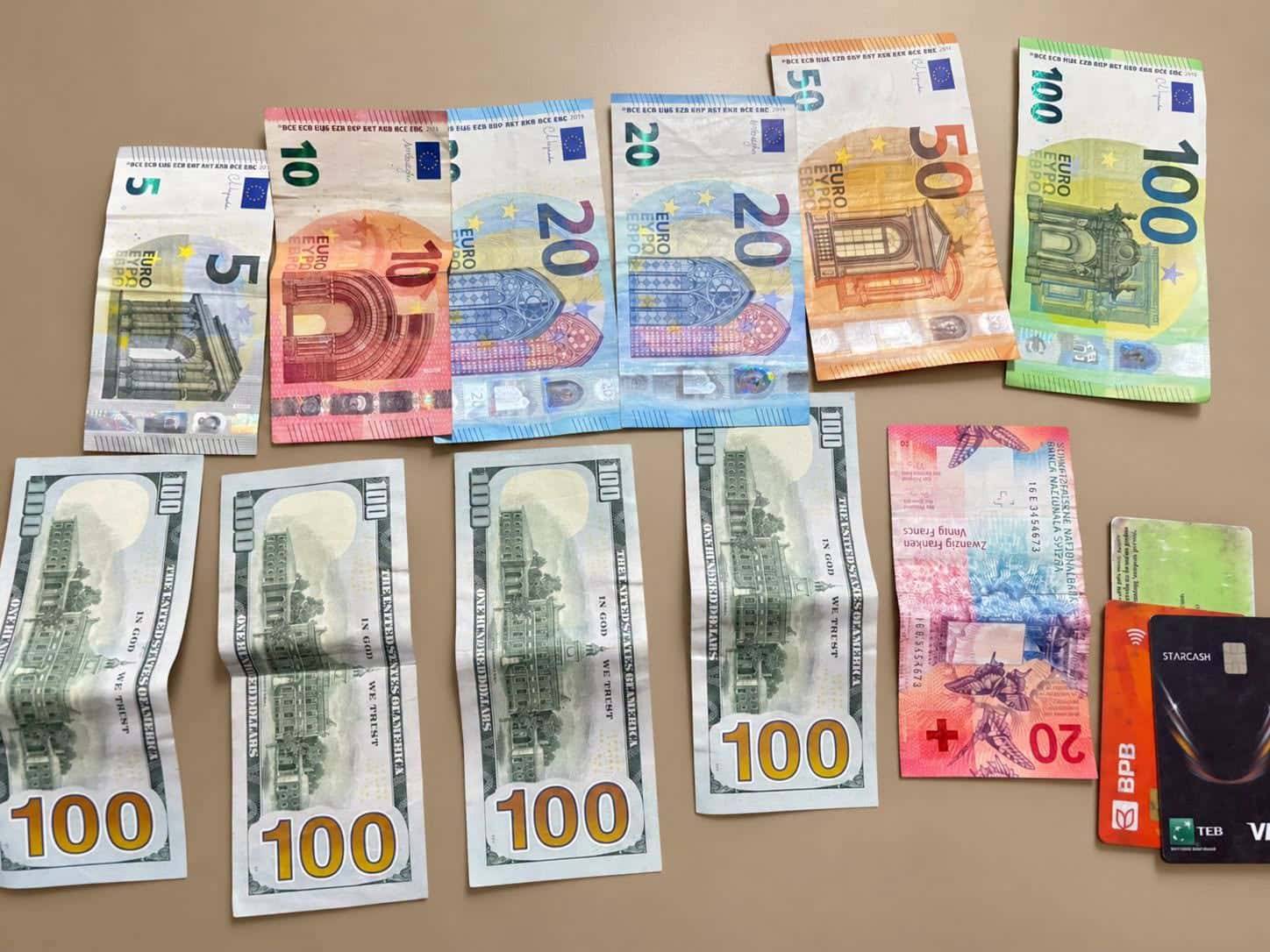 Citizens hand over a wallet found with money and personal documents to the police